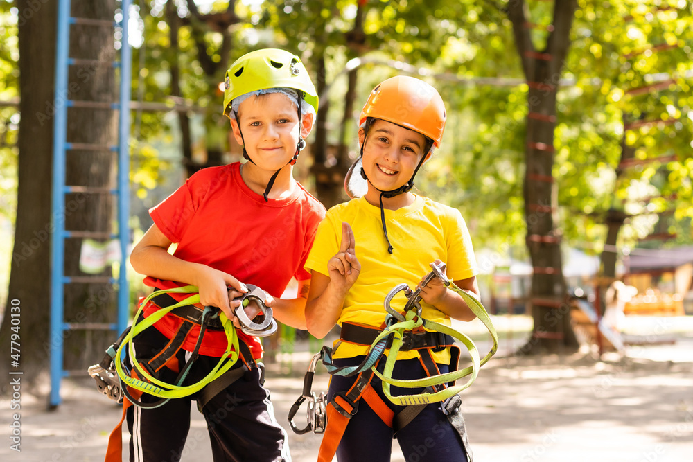 Happy child climbing in the trees. Rope park. Climber child. Early childhood development. Roping park. Balance beam and rope bridges. Rope park - climbing center Happy child climbing in the trees. Rope park. Climber child. Early childhood development. Roping park. Balance beam and rope bridges. Rope park - climbing center