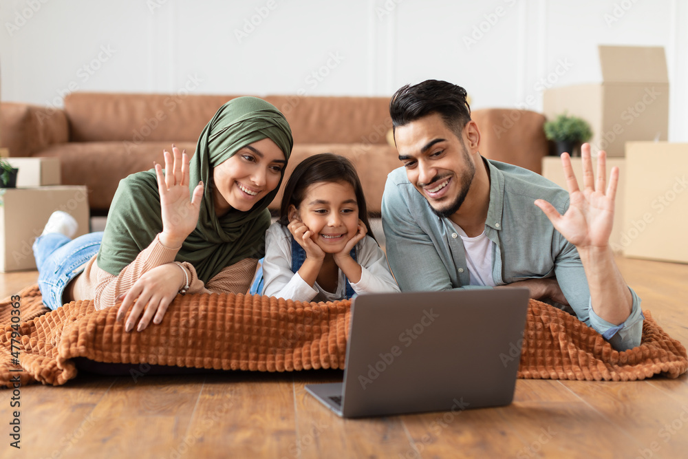 Arabic family having videocall using laptop waving hands Arabic family having videocall using laptop waving hands