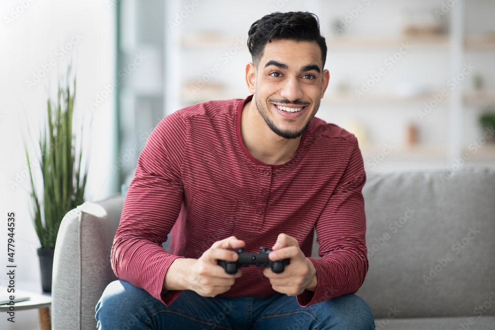 Young arab man playing video games at home Young arab man playing video games at home