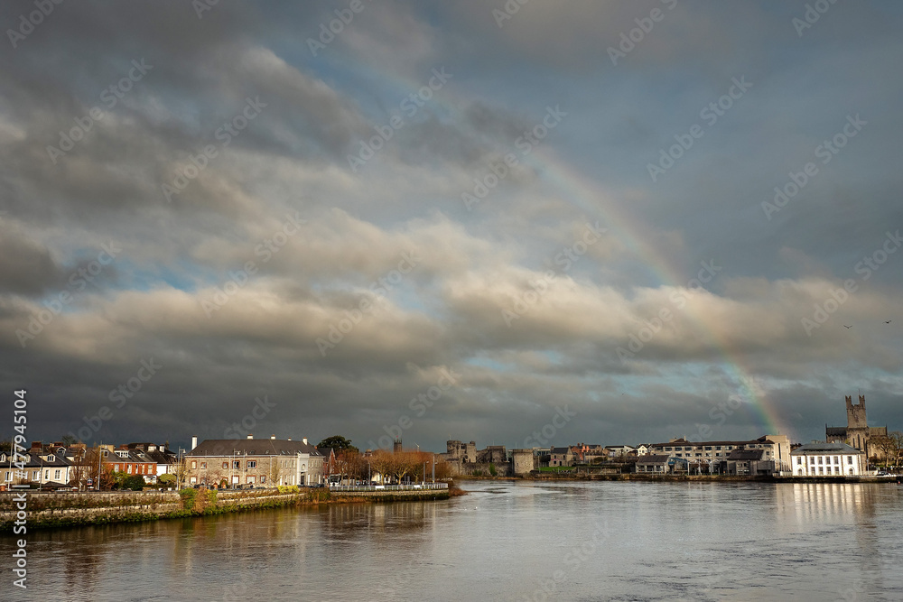 Rainbow in the sky over Limerick City District Court building and St Mary's Cathedral. Ireland. River Shannon. Popular town landmark and tourist spot. Cloudy sky. Irish luck and stunning nature event.