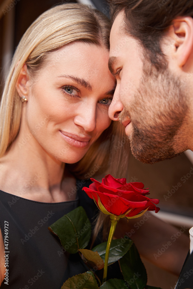 Female with rose looking at camera near her partner Female with rose looking at camera near her partner