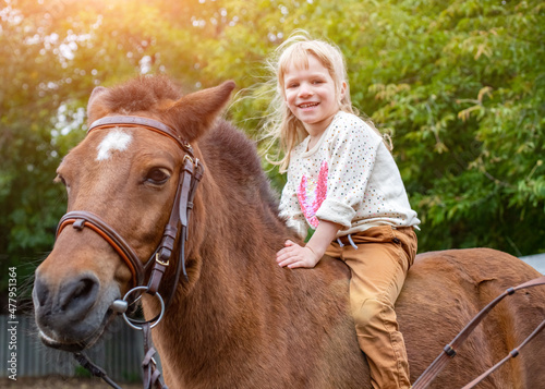 happy little girl riding a horse bareback