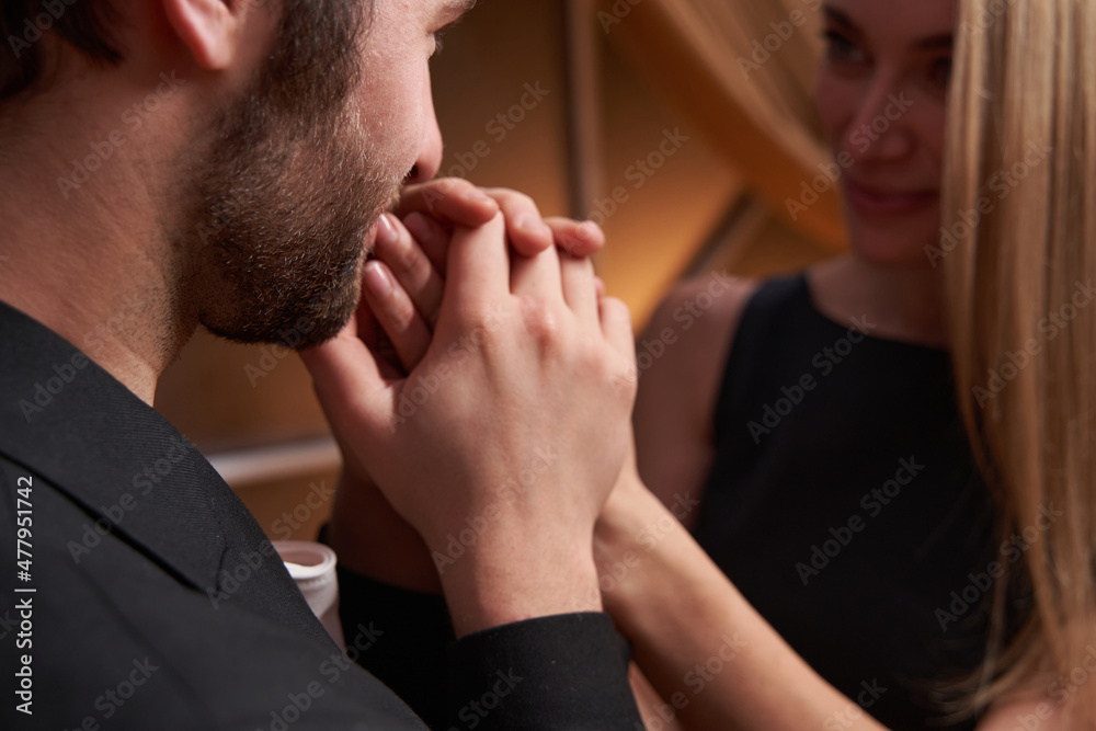 Male is kissing woman fingers in restaurant Male is kissing woman fingers in restaurant