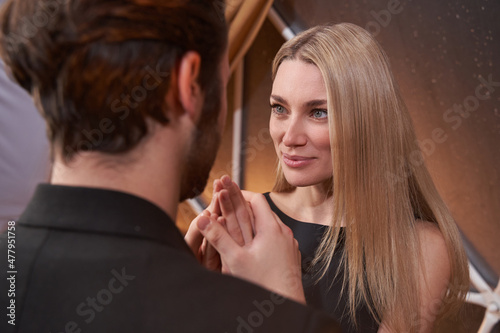 Woman looking at romantic partner while he holding her hands