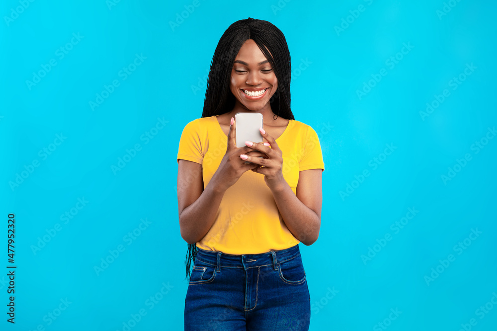 African American Woman Using Mobile Phone Posing Over Blue Background African American Woman Using Mobile Phone Posing Over Blue Background
