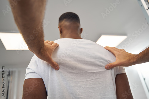 Fotografi Man having his upper back examined by medical specialist