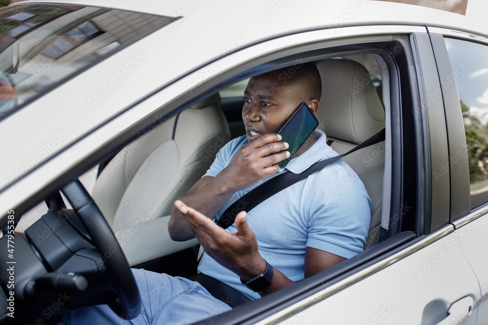 Angry black man having phone conversation while driving car