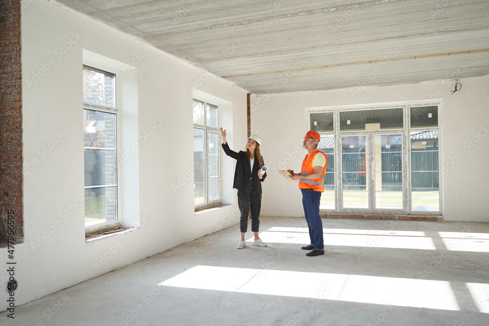 Woman engineer pointing hand at upper part of window Woman engineer pointing hand at upper part of window