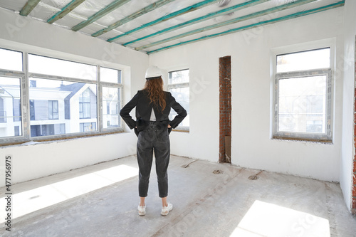 Female construction engineer in room with back to camera