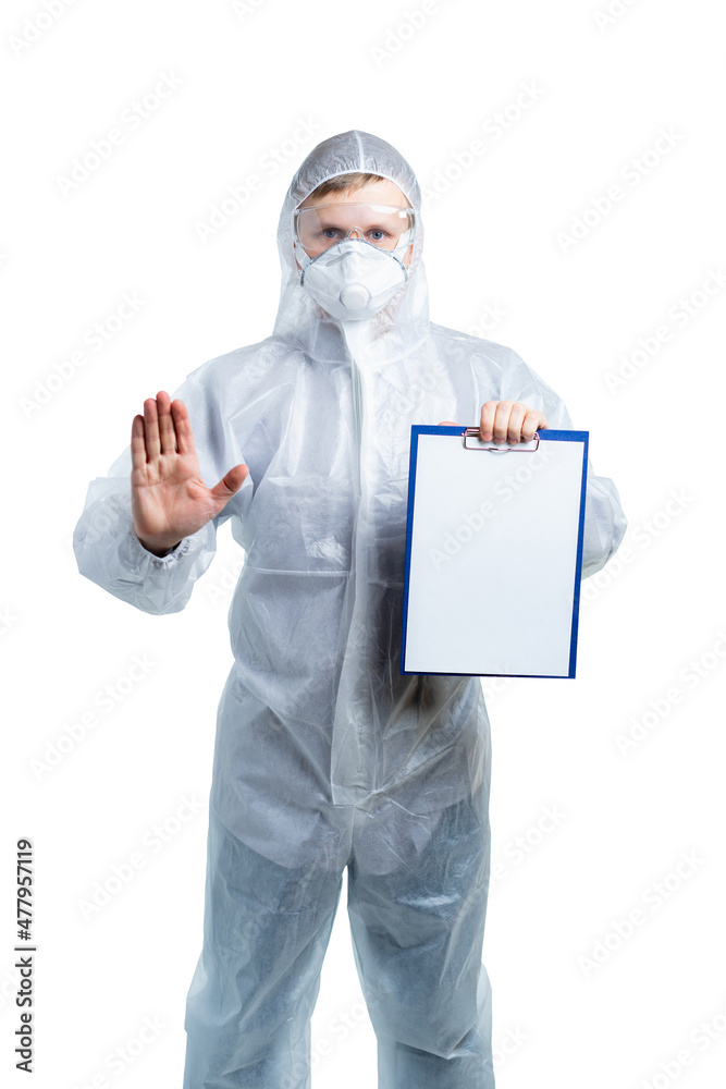 A scientist in special protective clothing holds a tablet with paper and shows a stop sign with his hand. Bacteria, viruses, toxic, caustic substances, coronavirus epidemic, flu. isolated A scientist in special protective clothing holds a tablet with paper and shows a stop sign with his hand. Bacteria, viruses, toxic, caustic substances, coronavirus epidemic, flu. isolated