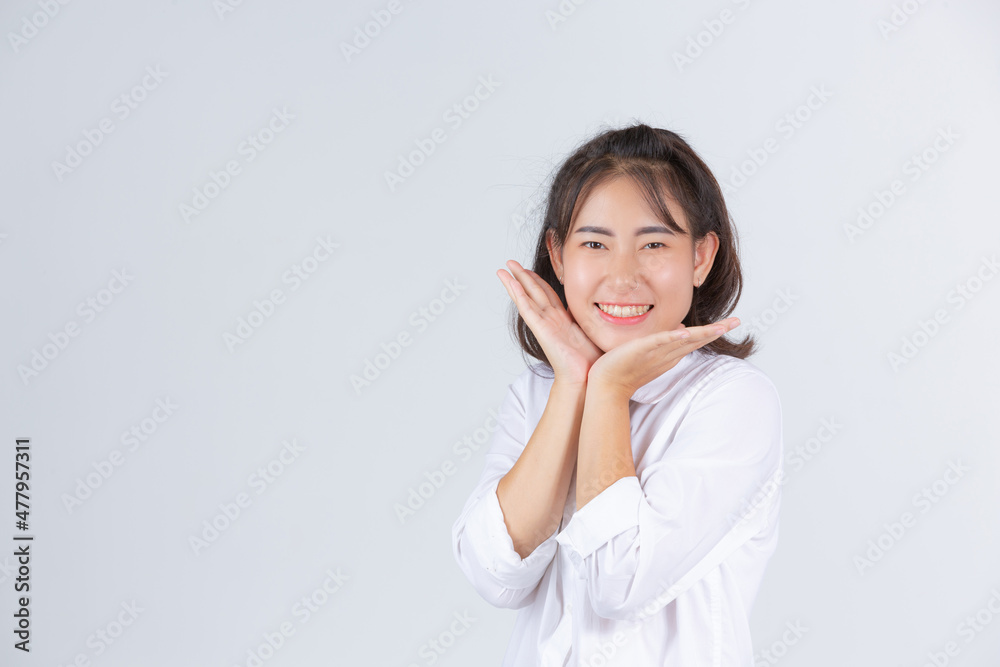 A young woman smiling cheerfully on a white background. A young woman smiling cheerfully on a white background.