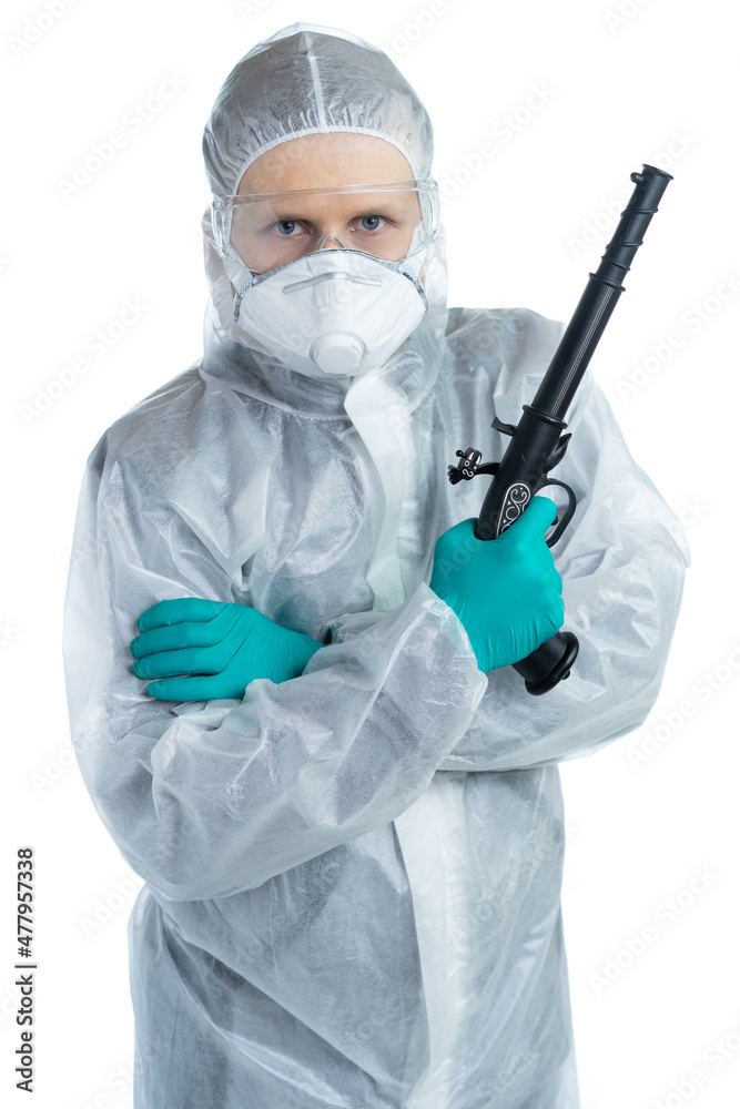A man in a white suit and gloves in personal protective equipment holds a gun and looks at the camera. Precautions personal protection. Specialist is ready for protection. isolated
