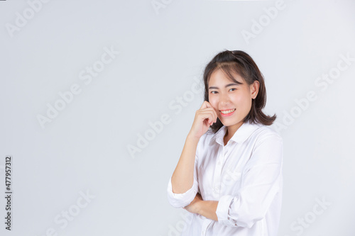 A young woman smiling cheerfully on a white background.