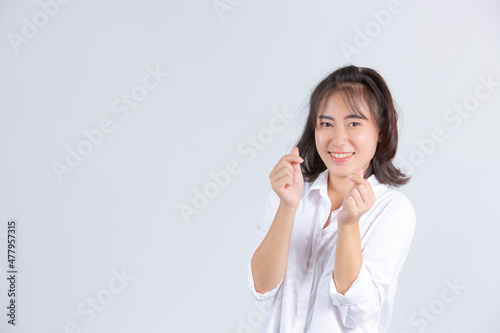 A young woman smiling cheerfully on a white background.