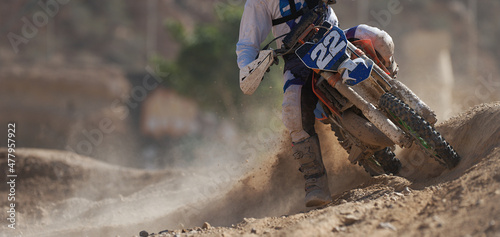 Fototapeta Naklejka Na Ścianę i Meble -  Racer boy on motorcycle participates in motocross race, active extreme sport, flying debris from a motocross in dirt track