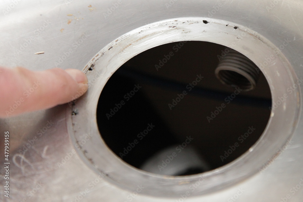 Modern kitchen gray metallic sink drainage hole rupture corrosion close up
