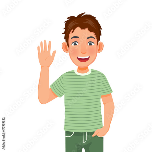 Handsome happy young man with hand in the pocket, smiling, waving hand cheerfully saying hi, hello nice to meet you, welcoming people with informal greeting gesture