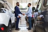 Black Car Seller Shaking Hands With Customer In Modern Dealership Center