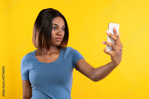 African Lady Unlocking Phone Via Face ID App, Yellow Background