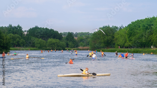 a crowd of kayakers on the water in the summer on the river