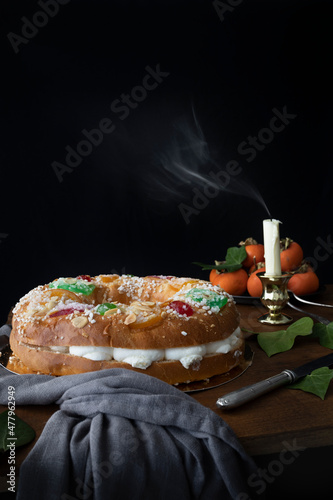 King cake with cream and fruit. Typical Christmas sweet in Spain with dark background. Cake for a celebration photo