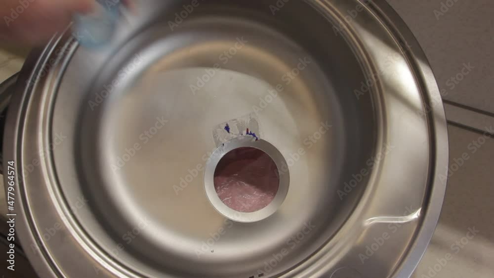 Removing glue of the sticker with solvent from the sprayer from the surface of the new metal kitchen sink Removing glue of the sticker with solvent from the sprayer from the surface of the new metal kitchen sink