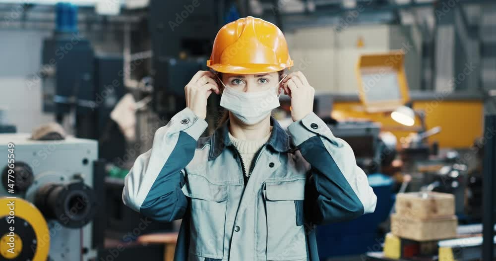 Portrait of a professional heavy industry engineer worker putting on a face shield at a steel mill. A beautiful woman industrialist in a hard hat standing at the object of metal structures. Portrait of a professional heavy industry engineer worker putting on a face shield at a steel mill. A beautiful woman industrialist in a hard hat standing at the object of metal structures.