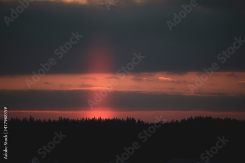 Rare optical phenomenon view in winter. Bright orange light pillar with ice crystals in cold air, Lithuania. Selective focus on the details, blurred background.