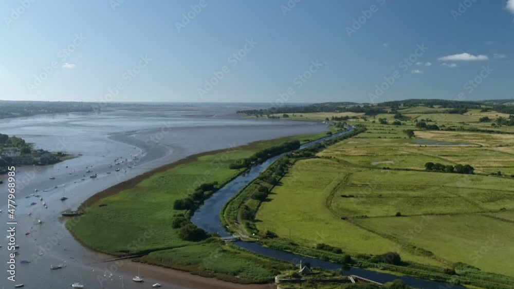 Artificial waterway moving through low level flat green landscape next to the mouth of the river exe, Devon Artificial waterway moving through low level flat green landscape next to the mouth of the river exe, Devon