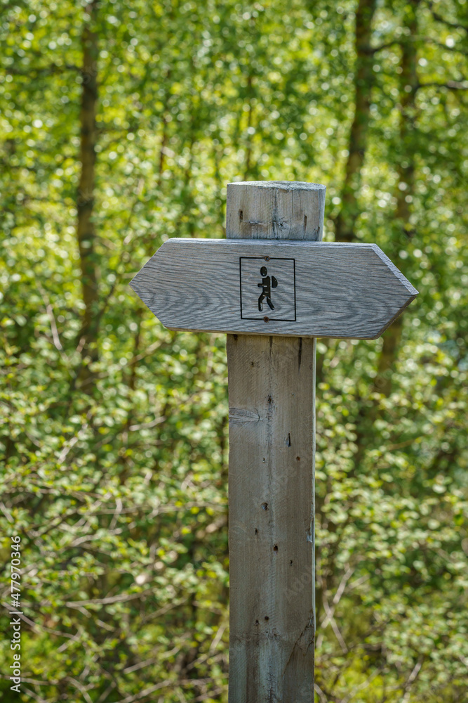 Wooden hiking post showing the hiking direction in the nature of Norway.