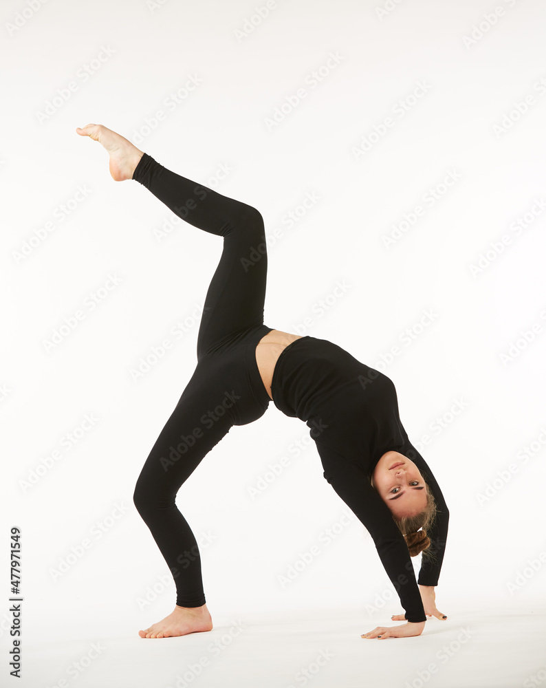 Naklejka premium A girl in black clothes on a white isolated background performs dance and ballet poses and movements.