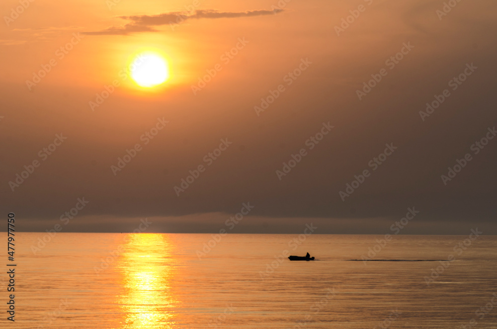 Motor boat on the background of the sunset. Beautiful red sun 