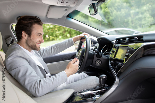 european man in suit is driving in city and looking at gps map