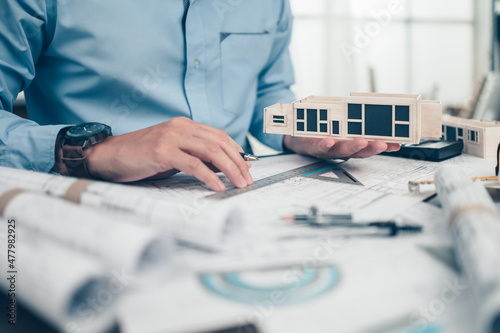 Architect engineer hold house model in hand. House planning design and construction concept.