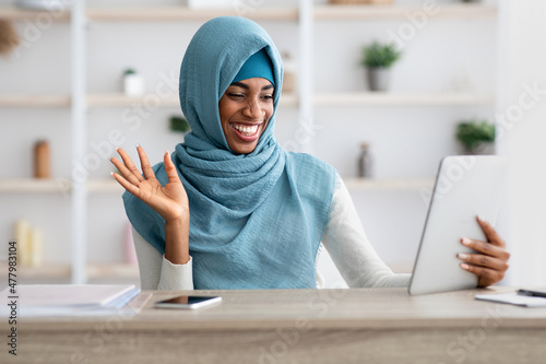 Online Communication. Cheerful Black Muslim lady In Hijab Making Video Call With Digital Tablet