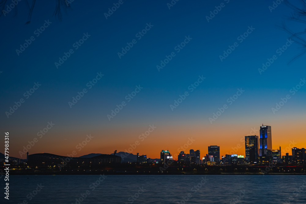 겨울 강의 일몰 후 하늘의 파란색과 붉은색 대비