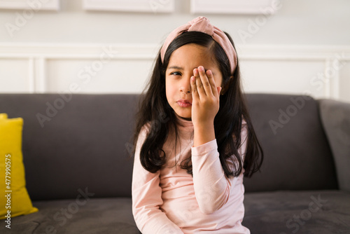 Sad elementary girl with conjunctivitis photo