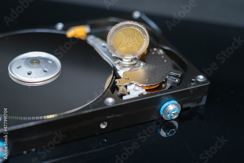  euro coin is standing on an open hard drive