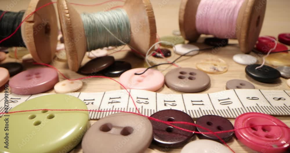 Tailor's workshop with threads on spools and tape measure. Close up of a tailor's work desk with tailoring tools Tailor's workshop with threads on spools and tape measure. Close up of a tailor's work desk with tailoring tools