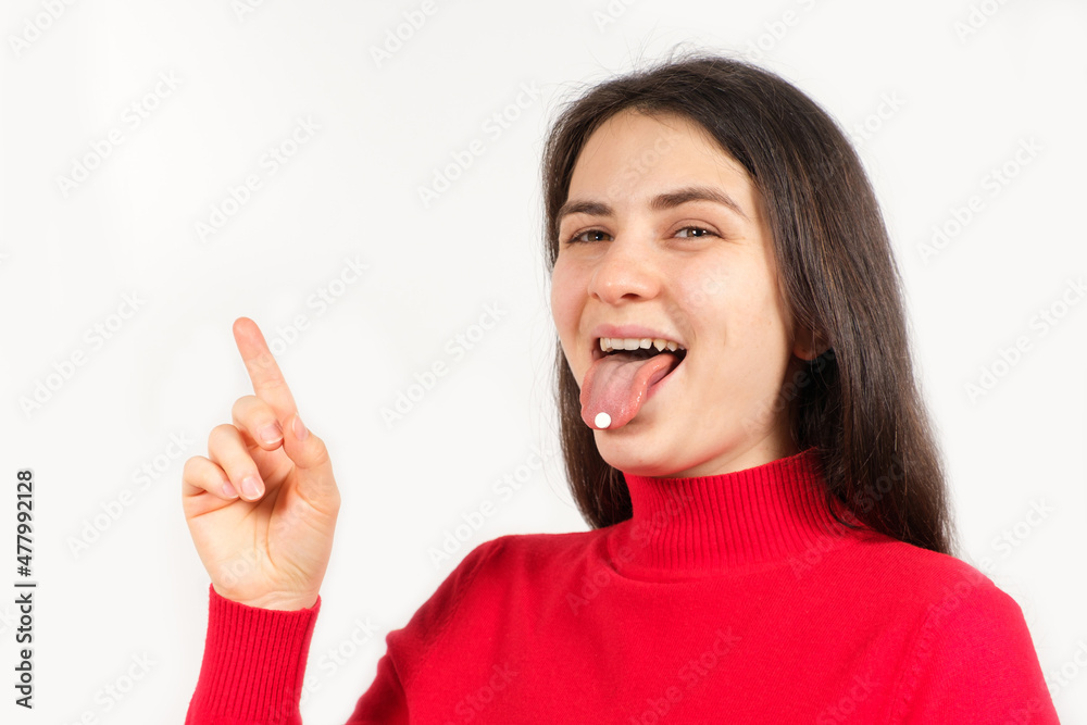 A woman in red with pills on her tongue points her finger at a place for text