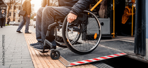 Person with a physical disability exits public transport with an accessible ramp. photo