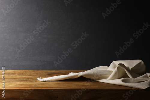 Natura morta con tessuto di lino bianco su tavola in legno, isolato su fondo scuro con spazio per testo photo