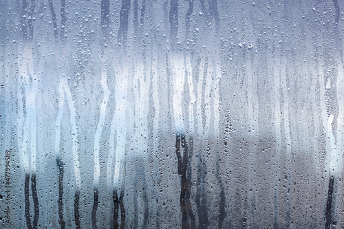 Drops of condensate on the sweaty glass. Cold foggy glass