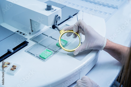 Laboratory assistant works at paraffin wax dispenser tissue embedding machine.