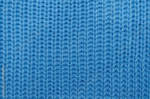 Knitted fabric. Blue knitted rug close-up. Textile texture on a blue background. Detailed warm yarn background. Knit cashmere wool. Natural woolen fabric, a fragment of a sweater. Knitting pattern