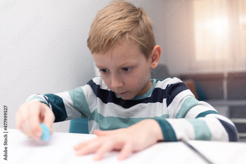 School boy practicing writing the alphabet at home. Boy child kid writing. Homework. School boy practicing writing the alphabet at home. Boy child kid writing. Homework.