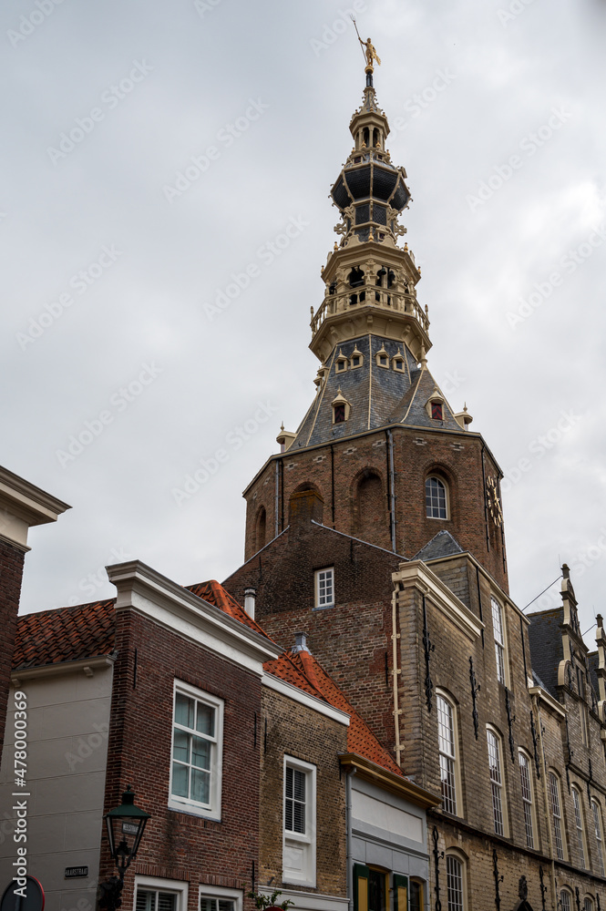 Obraz premium Walking in old Dutch town Zierikzee with old church tower, small houses and streets