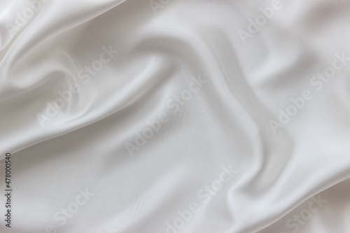 White silk fabric background. Abstract texture for design. Flowing satin waves.