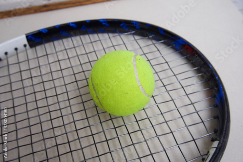 Yellow tennis ball on a paddle racket © enriscapes