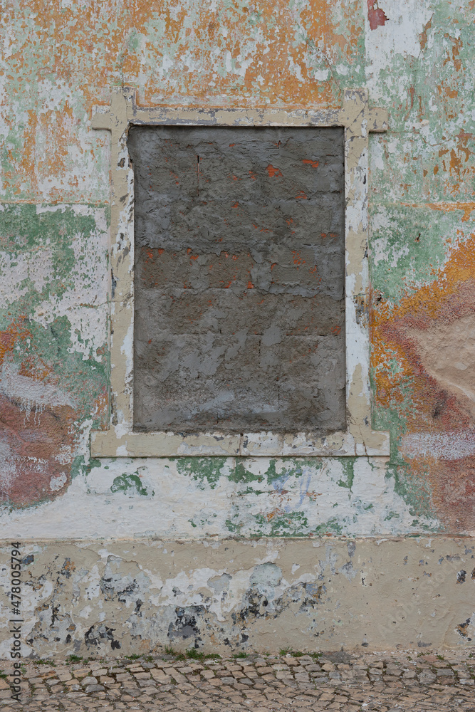 old brown covered window on an old painted wall old brown covered window on an old painted wall